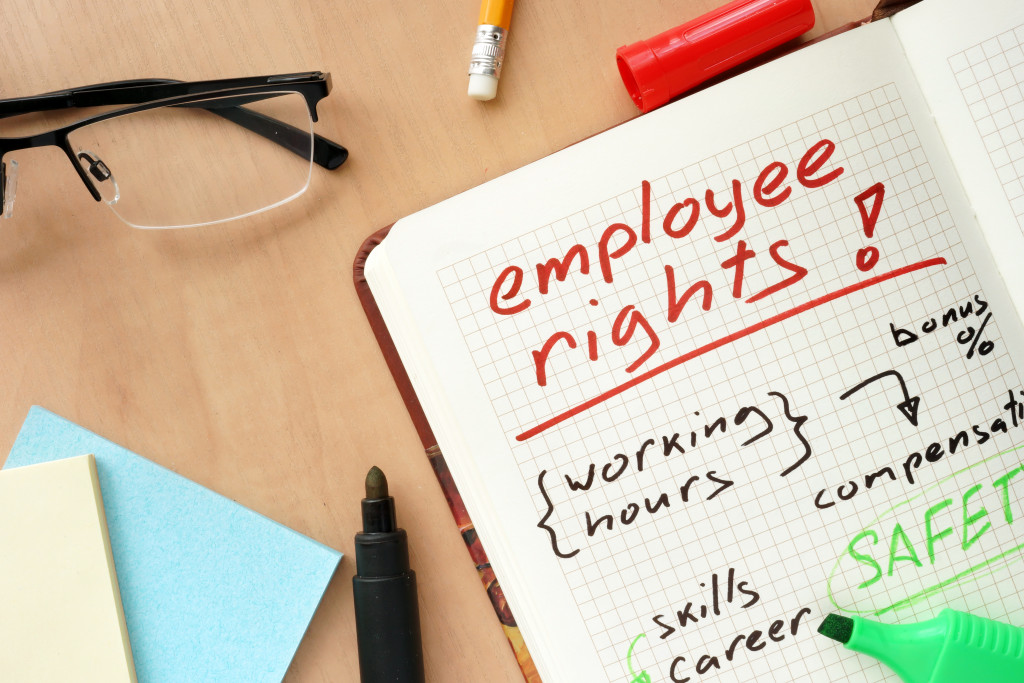 Employee rights and related concepts written on a notebook on a cluttered desk