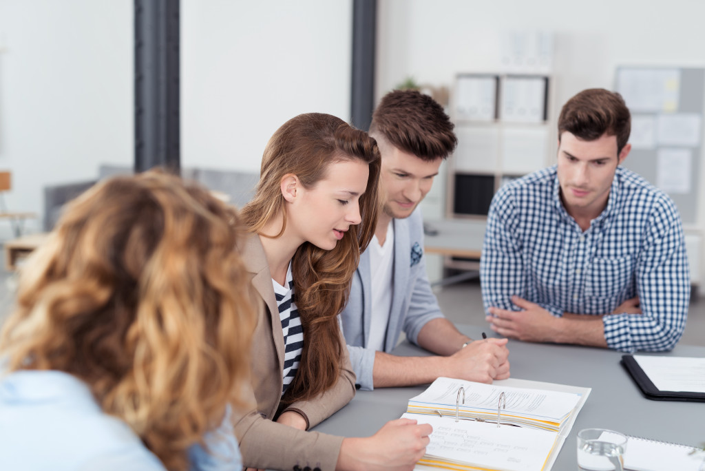 Young office workers receiving instructions in an office during a meeting.