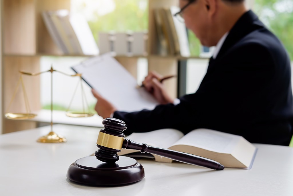 Legal professional checking cases to handle with a gavel on a table in front of him.