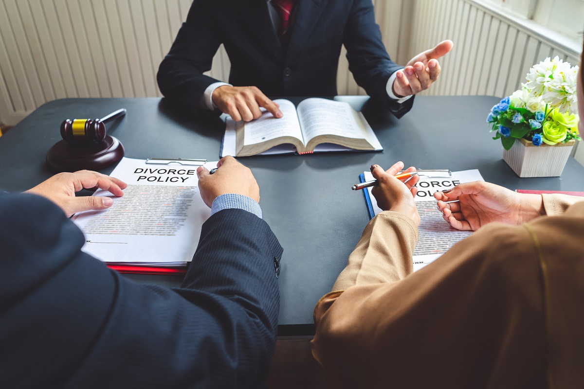 couple talking to divorce lawyer about to sign document